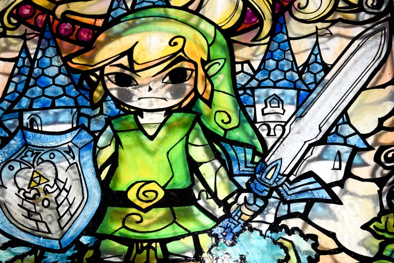 Puede incluir: Una ilustraci&oacute;n de vitral de Link de la serie de videojuegos The Legend of Zelda. Link est&aacute; representado con su t&uacute;nica y gorro verdes, sosteniendo una espada y un escudo. El fondo presenta un castillo azul y un bosque verde.