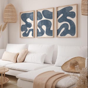 Navy blue organic shape triptych set styled in a bright minimalist living room with a white sofa and boho accents.