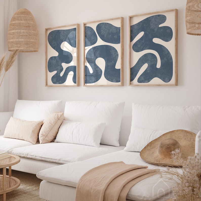 Navy blue organic shape triptych set styled in a bright minimalist living room with a white sofa and boho accents.