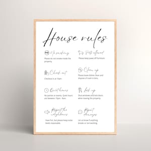 May include: A framed print with the words "House rules" in elegant script. The white background features black text and icons detailing rules like "No smoking," "Pets allowed," and "Quiet hours."