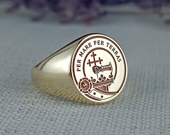 Könnte beinhalten: Ein goldener Siegelring mit einem roten und goldenen Wappen, das ein Kreuz und den Text "Per Mare Per Terras" zeigt.