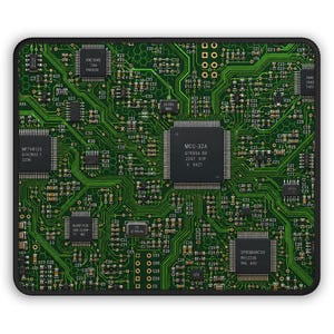 May include: A rectangular mouse pad featuring a detailed green printed circuit board design with black integrated circuit chips, gold-colored contact points, and intricate copper-colored pathways throughout the entire surface area.