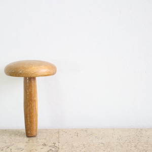 Peut inclure: Un tabouret en bois en forme de champignon avec une finition brun clair.