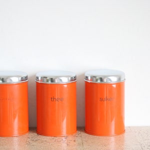 Three vintage orange metal tins for tea, coffee & sugar from Brabantia Holland