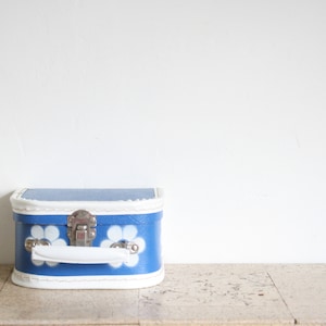 Maleta vintage pequeña de cartón azul con flores blancas para niños de los años sesenta
