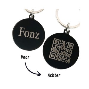 Op de afbeelding: Zwarte ronde sleutelhanger met een zilveren sleutelring. De voorkant is gegraveerd met de naam "Fonz". De achterkant heeft een zwart-witte QR-code.