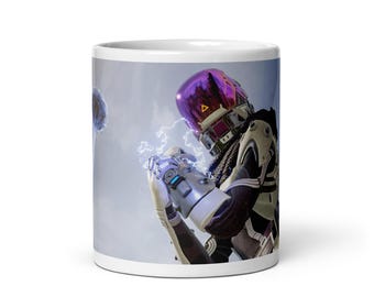 May include: White ceramic mug featuring a futuristic character with a purple helmet and silver armor, holding a glowing energy effect. The design is set against a cloudy sky background, creating a sci-fi theme.