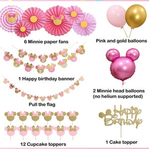 May include: Pink and gold Minnie Mouse themed party decorations including paper fans, a banner, cupcake toppers, a cake topper, and balloons. The banner says "Happy Birthday".