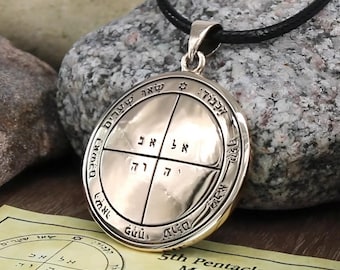 Może przedstawiać: Złoty wisiorek z hebrajskim tekstem i symbolami, zawieszony na czarnym sznurku. Wisiorek ma okrągły kształt ze skomplikowanymi detalami i jest dołączony do papieru z dodatkowym tekstem. Tekst na papierze brzmi "5th Pentacle of Mercury Key of Solomon".