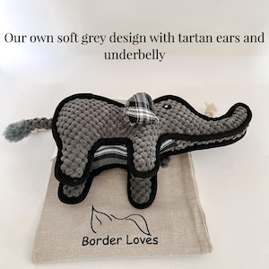 May include: A grey plush elephant dog toy with a tartan pattern on the ears and belly. The toy is on a beige fabric bag with the text "Border Loves" printed on it.