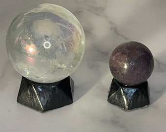 Soportes negros para exhibir bolas de cristal, esferas y huevos.