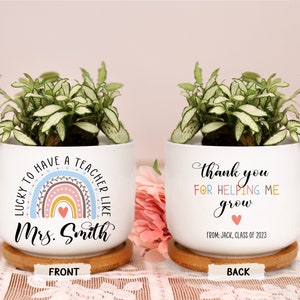 May include: White ceramic planter with a plant, featuring a rainbow design and the text "LUCKY TO HAVE A TEACHER LIKE Mrs. Smith" on the front. The back says "thank you FOR HELPING ME grow" with a heart and "FROM: JACK, CLASS OF 2023".