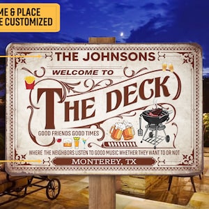 May include: Customizable metal sign with the text "The Deck" and "The Johnsons". The sign features illustrations of a grill, beer mugs, and fries. The sign also includes the text "Good Friends Good Times" and "Monterey, TX".