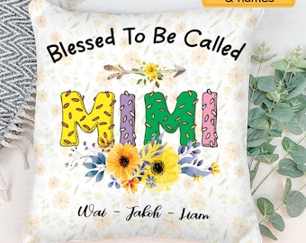 May include: A white square pillow with the words "Blessed To Be Called MIMI" in colorful letters. The pillow features floral accents, including sunflowers and an arrow design. The names Wai, Jakob, and Liam are printed below.