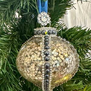 Stunning Champagne Glittered Glam ornament embellished with Rhinestones and Dark Blue Pearls with a mini faux crystal topper and blue ribbon