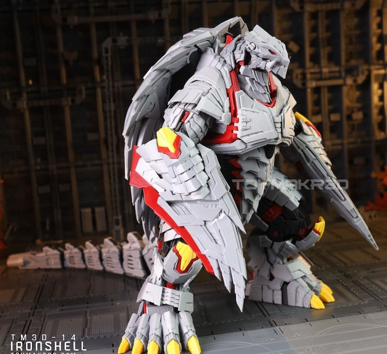 Op de afbeelding: Een grijs en rood robot speelgoed met een dinosaurusachtig ontwerp. De robot heeft vleugels en een lange staart. Het speelgoed is gemaakt van plastic en heeft een gedetailleerd ontwerp.