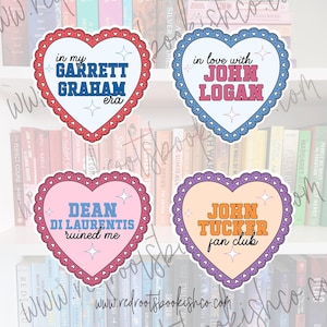 May include: Four heart-shaped stickers with scalloped borders. The top left is white with red trim and blue text reading in my GARRETT GRAHAM era. The top right is white with blue trim and pink text reading in love with JOHN LOGAN. The bottom left is pink with purple trim and blue text reading DEAN DI LAURENTIS ruined me. The bottom right is peach with purple trim and orange text reading JOHN TUCKER fan club.