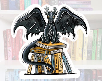 May include: A black dragon with wings outstretched is perched atop a stack of books. The dragon has yellow eyes and horns. The books are stacked in a pile with the spines facing outwards. The books have various titles and authors.