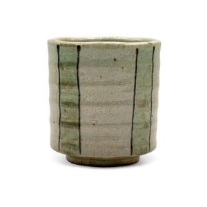 May include: A small, white ceramic cup with green and black stripes. The cup has a rounded bottom and a slightly flared rim.