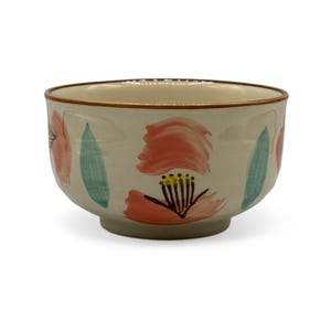 May include: A white ceramic bowl with a floral design. The bowl has pink and green flowers painted on it.
