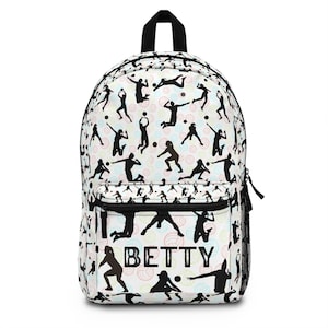 May include: White backpack with a black top handle, black zipper, and side mesh pocket. The backpack features a pattern of black volleyball players in action with colorful volleyballs. The name "BETTY" is printed on the front.