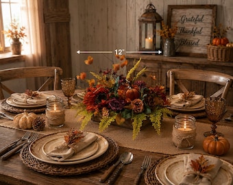 May include: A 12-inch wide autumn-themed centerpiece featuring artificial sunflowers, roses, and foliage in a wooden box, displayed on a dining table with plates, burlap-wrapped mason jar candles, and small pumpkins for a seasonal table setting.