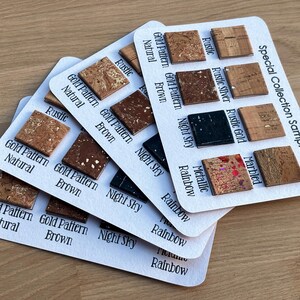 May include: Close-up of cork samples for earrings, showing different patterns and colors, including gold, brown, night sky, metallic, rainbow, and marbled. The samples are labeled with their names and arranged on white cards. The text "Special Collection Samples" is printed on the top right corner of the card.