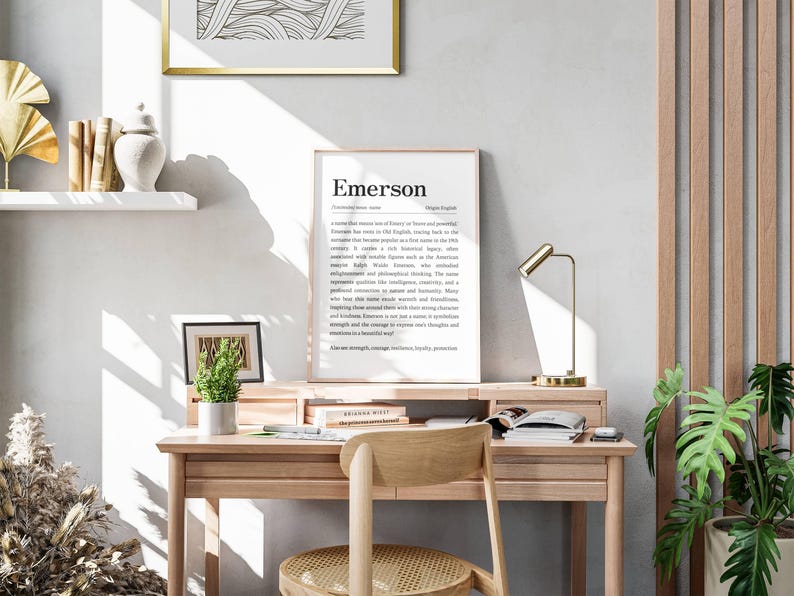 Peut inclure: Un bureau en bois clair avec une chaise assortie, une impression encadr&eacute;e avec le nom "Emerson" et une petite plante en pot. Une lampe de bureau dor&eacute;e et une image encadr&eacute;e sont &eacute;galement sur le bureau. La pi&egrave;ce a une palette de couleurs neutres.