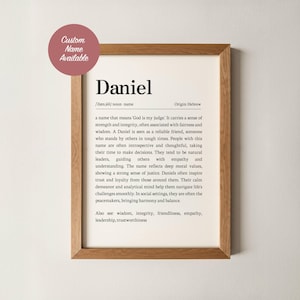 May include: A framed print featuring the name "Daniel" in a bold font, with a definition and origin. The text describes Daniel's characteristics, such as strength, integrity, and leadership. A circular sticker in the upper left corner says "Custom Name Available".