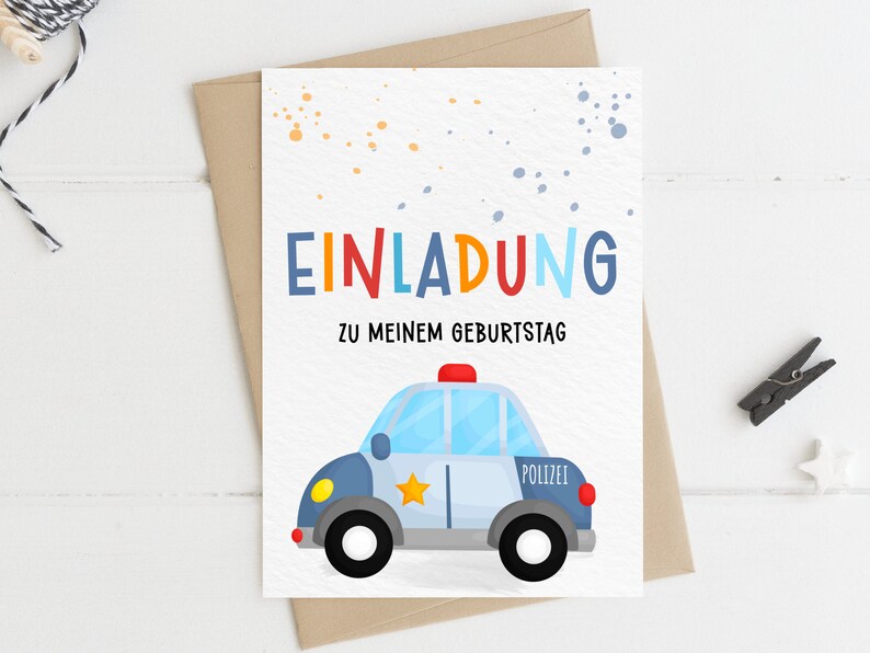 May include: A white card with colorful polka dots and the text "EINLADUNG" in rainbow colors. Below the text is "ZU MEINEM GEBURTSTAG". A cartoon blue and gray police car with a red light on top is at the bottom of the card.
