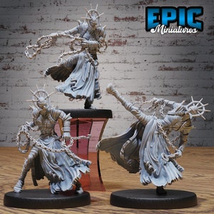 May include: Three gray 3D printed miniatures of figures with a halo and chains. The figures are posed in dynamic action poses. The figures are on round bases. The figures are from Epic Miniatures.