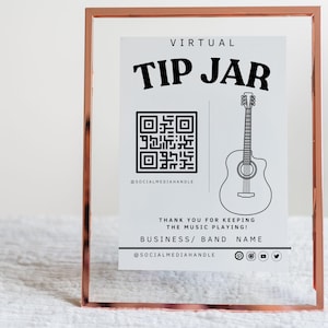 May include: A white sign in a gold frame with the text "VIRTUAL TIP JAR" and a QR code. The sign also includes a drawing of a guitar and the text "THANK YOU FOR KEEPING THE MUSIC PLAYING! BUSINESS/ BAND NAME @SOCIALMEDIAHANDLE".