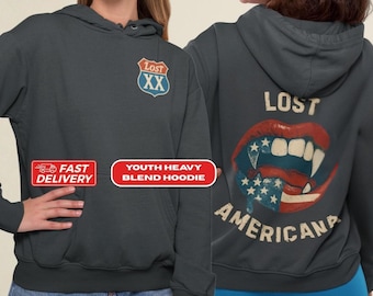 May include: Dark gray youth heavy blend hoodie with a front pocket and hood. The front features a red, white, and blue shield graphic with the text "Lost XX". The back displays a mouth graphic with fangs and an American flag design, with the word "Americana".