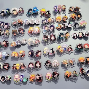 May include: A collection of colorful anime character hair clips. The clips feature various characters from the popular anime series Demon Slayer. The clips are made of clear plastic and feature detailed images of the characters.