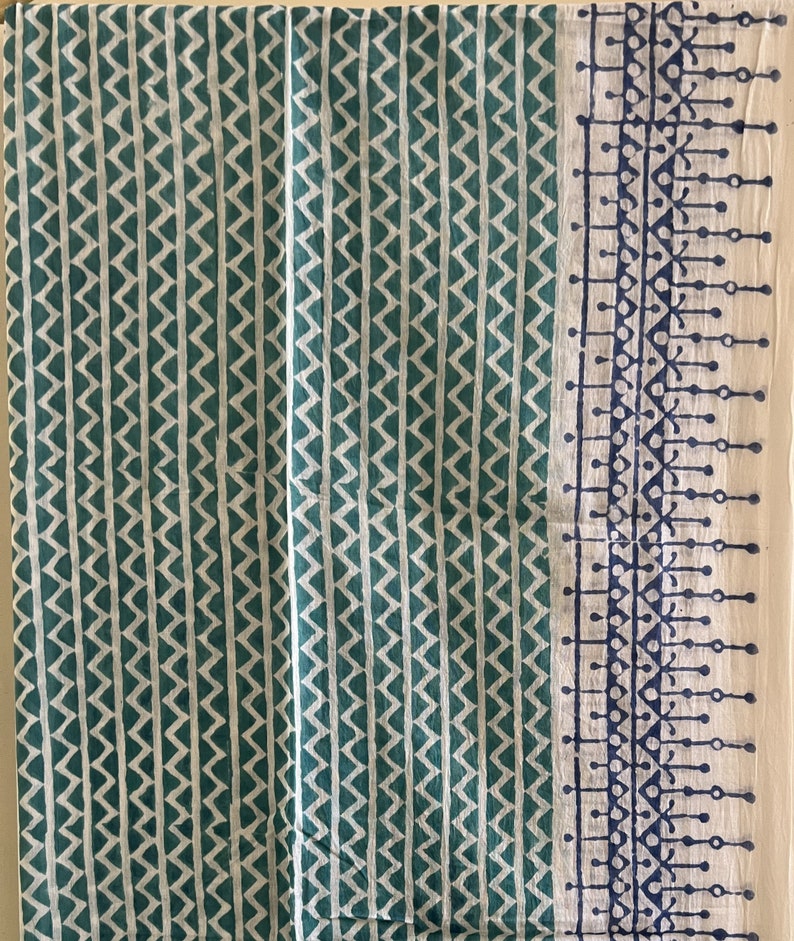 May include: White fabric with a teal chevron pattern and a blue and white border with a geometric design.