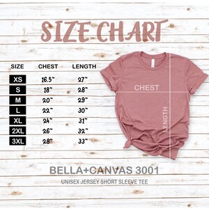 Peut inclure: Tableau des tailles pour un t-shirt &agrave; manches courtes en jersey unisexe, indiquant les mesures de la poitrine et de la longueur en pouces pour les tailles XS &agrave; 3XL. Le tableau est imprim&eacute; sur un fond en bois blanc. Bella + Canvas 3001.