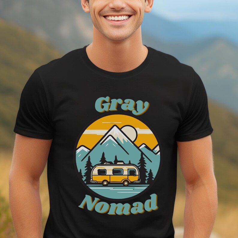 Peut inclure: Un t-shirt noir avec un graphique r&eacute;tro d'un camping-car jaune conduisant &agrave; travers un paysage de montagne. Le texte "Gray Nomad" est imprim&eacute; dans une police r&eacute;tro.