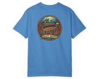 May include: A light blue t-shirt with a circular graphic depicting a treasure chest overflowing with gold coins, framed by a rope border. The design includes a skull, fish, and the text "SALTY ENUFF" on a banner.