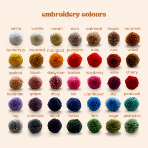 以下が含まれることがあります： 「embroidery colours」と題されたカラーチャートには、様々な色合いの35個の丸い毛糸のポンポンがグリッド状に並んでいます。各ポンポンには、白、バニラ、クリームからネイビー、フォレスト、ピスタチオまで、対応する色名がラベル付けされています。