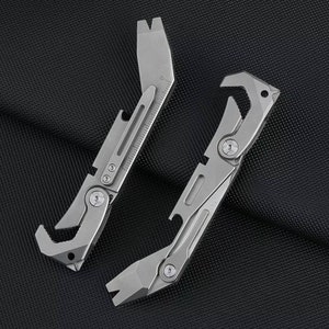 Peut inclure: Deux outils multifonctions argentés avec une variété de fonctions, notamment un ouvre-bouteille, un levier et une clé. Les outils sont en métal et ont un design élégant et moderne.