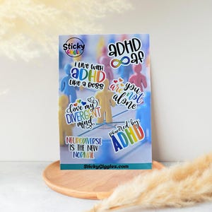 Puede incluir: Una hoja de pegatinas coloridas con varias frases relacionadas con el TDAH y la neurodiversidad. Las pegatinas presentan textos como "ADHD af", "I live with ADHD like a boss" y "Neurodiverse is the new normal". El fondo incluye peque&ntilde;as figuras humanas de colores.