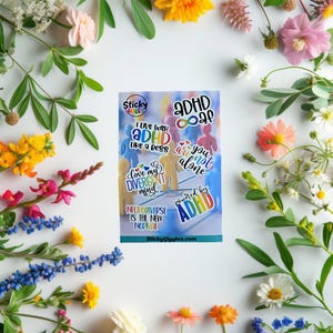 Puede incluir: Una hoja de pegatinas con dise&ntilde;os coloridos con el tema del TDAH y texto, incluyendo frases como "Vivo con TDAH como un jefe" y "Neurodiverso es la nueva normalidad". Las pegatinas presentan varios colores y fuentes, con un fondo de figuras azules y amarillas. Las pegatinas est&aacute;n rodeadas de una variedad de flores.