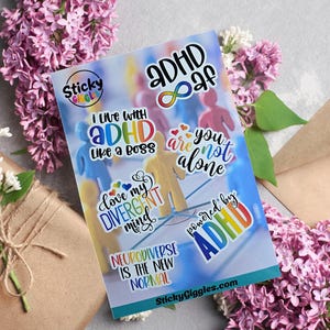 Puede incluir: Una hoja de pegatinas coloridas con frases relacionadas con el TDAH y la neurodiversidad. Las pegatinas presentan textos como "ADHD af", "I live with ADHD like a boss" y "Neurodiverse is the new normal". El fondo incluye peque&ntilde;as figuras humanas de colores.