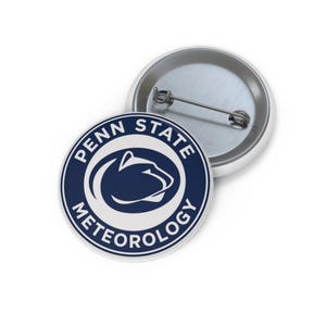 May include: Two round buttons. One button is face up, displaying a navy blue and white design with the words "PENN STATE METEOROLOGY" encircling a white graphic of a Nittany Lion head. The other button is face down, showing a silver pin back.