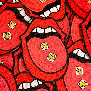 May include: Red felt patches with a tongue design and smiling pill graphics. The patches are sewn together to create a layered effect.
