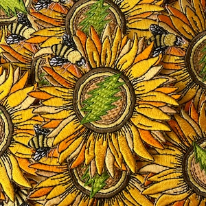 Könnte beinhalten: Gestickte Aufnäher mit Sonnenblumen mit gelben, orangefarbenen und braunen Blütenblättern. Jede Sonnenblume hat ein grünes Blitzdesign in der Mitte und ist von Bienen umgeben. Die Aufnäher sind dicht gepackt.