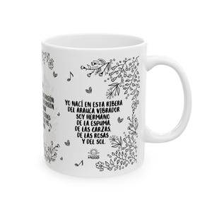 Puede incluir: Taza de cer&aacute;mica blanca con un dise&ntilde;o floral en blanco y negro y texto que dice "YO NAC&Iacute; EN ESTA RIBERA DEL ARAUCA VIBRADOR SOY HERMANO DE LA ESPUMA. DE LAS CARZAS. DE LAS ROSAS Y DEL SOL." El texto est&aacute; rodeado de un dise&ntilde;o floral y un peque&ntilde;o sol con la palabra "MOOD" debajo.