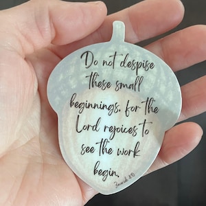 May include: A white acorn-shaped sticker with a quote from Zechariah 4:10: "Do not despise these small beginnings, for the Lord rejoices to see the work begin."