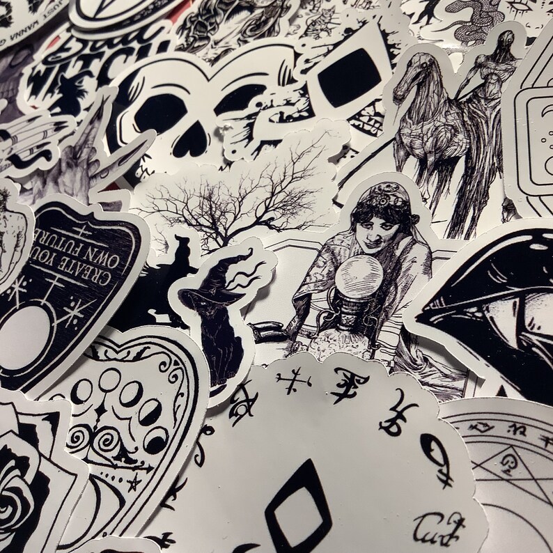 Puede incluir: Una colecci&oacute;n de pegatinas en blanco y negro con temas ocultos y g&oacute;ticos. Los dise&ntilde;os incluyen una calavera, una bruja con sombrero, una adivina con una bola de cristal y una tabla Ouija. Las pegatinas son de varias formas y tama&ntilde;os.