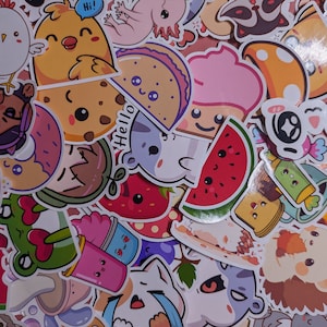 May include: A selection of colourful stickers with adorable illustrations. Designs include a chick with a speech bubble saying "Hi!", a cookie, a taco, a watermelon slice, a cat, and a strawberry. The stickers are in various shapes and sizes.